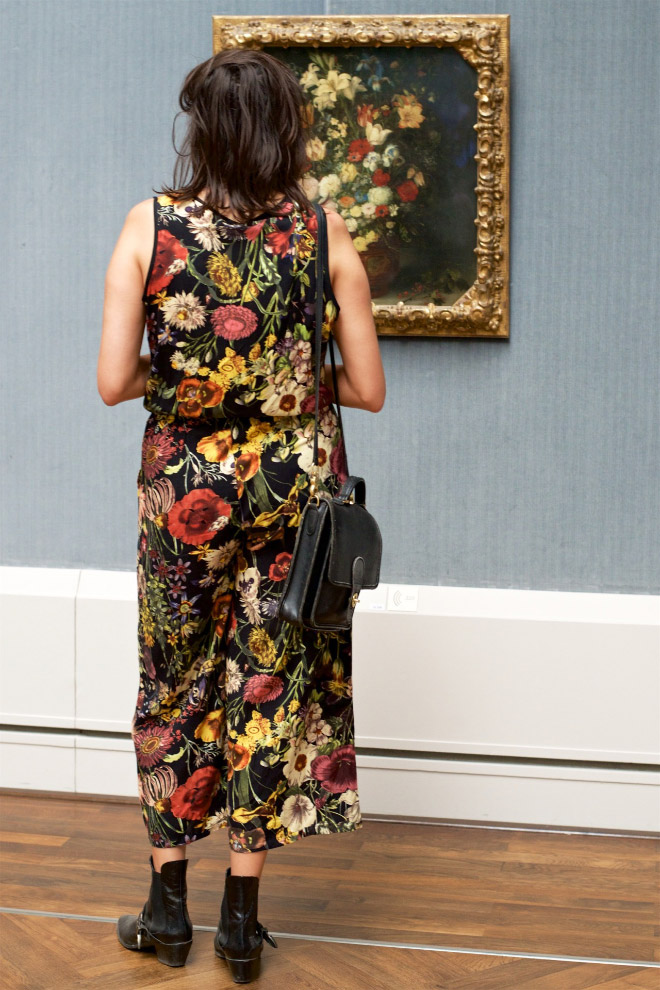 Woman's dress perfectly matching a painting in an art museum.