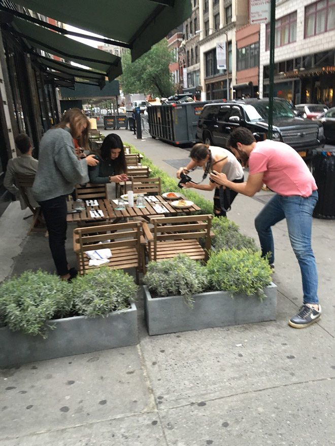 Bunch of hipsters taking pictures of their food.